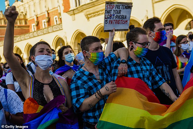 Protesters wear protective face masks and shout slogans as they take part in a protest against discrimination of the LGBT community two days before the Presidential elections runoff at Krakow