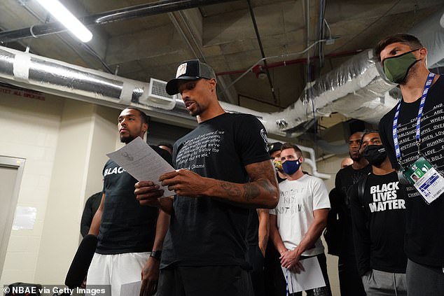 George Hill of the Milwaukee Bucks reads a statement to the media Wednesday announcing their protest and demanding justice for Blake