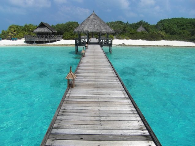 Dock and thatched roof huts in the Maldives.