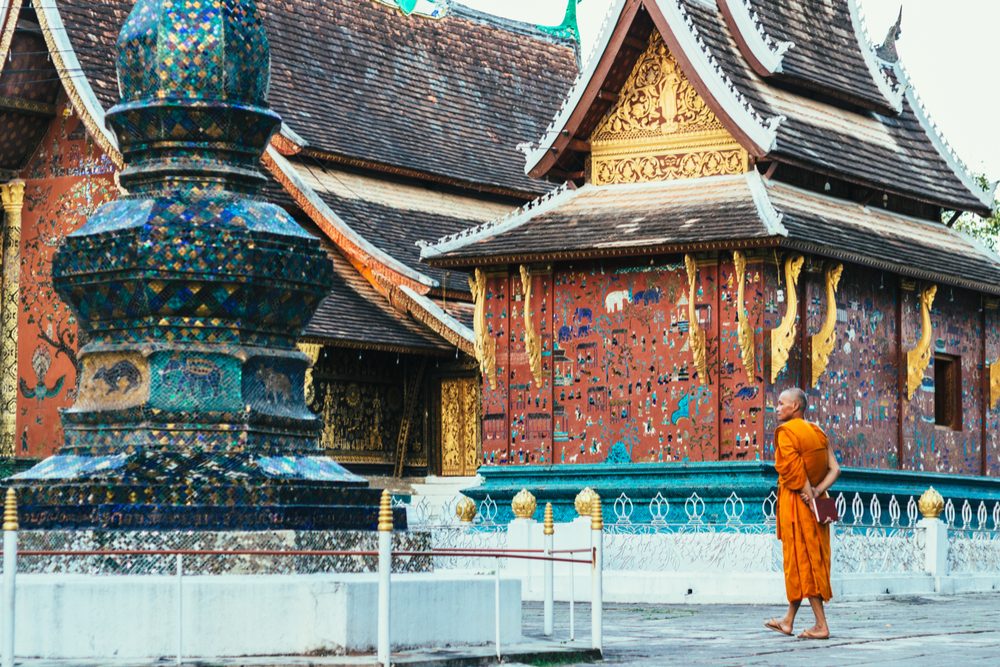 Luang Prabang, Laos - 26 November 2016: Buddhist monk and the details of architecture of Buddhist temple Wat Xieng Thong in Luang Prabang - UNESCO World Heritage Site